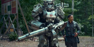 a-character-guiding-a-person-inside-a-suit-in-fallout