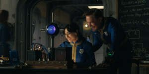 two-characters-laughing-while-looking-at-a-screen-in-fallout